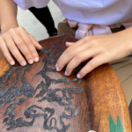 Mani che esplorano uno scudo in legno del Sestiere Sant'Emidio di Ascoli Piceno